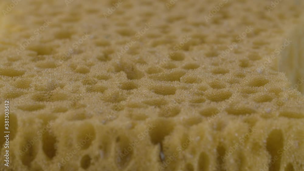 Extreme close up yellow dishwashing sponge with soap bubbles. Texture, background. Macro shot with slide or move camera. Extreme close up yellow dishwashing sponge with soap bubbles. Texture, background. Macro shot with slide or move camera.