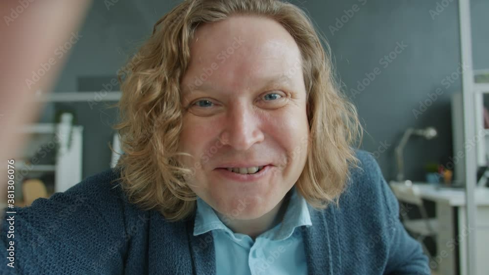 Portrait of cheerful young man talking online looking at camera gesturing in office communicating with business partners. People and work concept. Portrait of cheerful young man talking online looking at camera gesturing in office communicating with business partners. People and work concept.