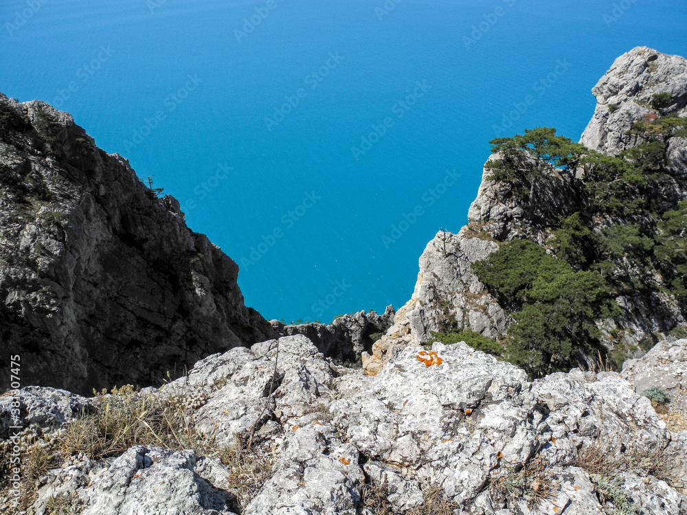 Steep cliffs on the background of the bright blue sea 