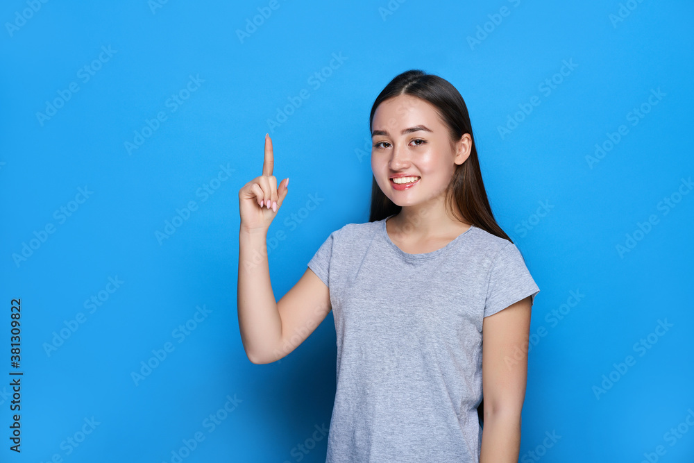 Young beautiful asian smiling and showing thumbs up on blue background Young beautiful asian smiling and showing thumbs up on blue background