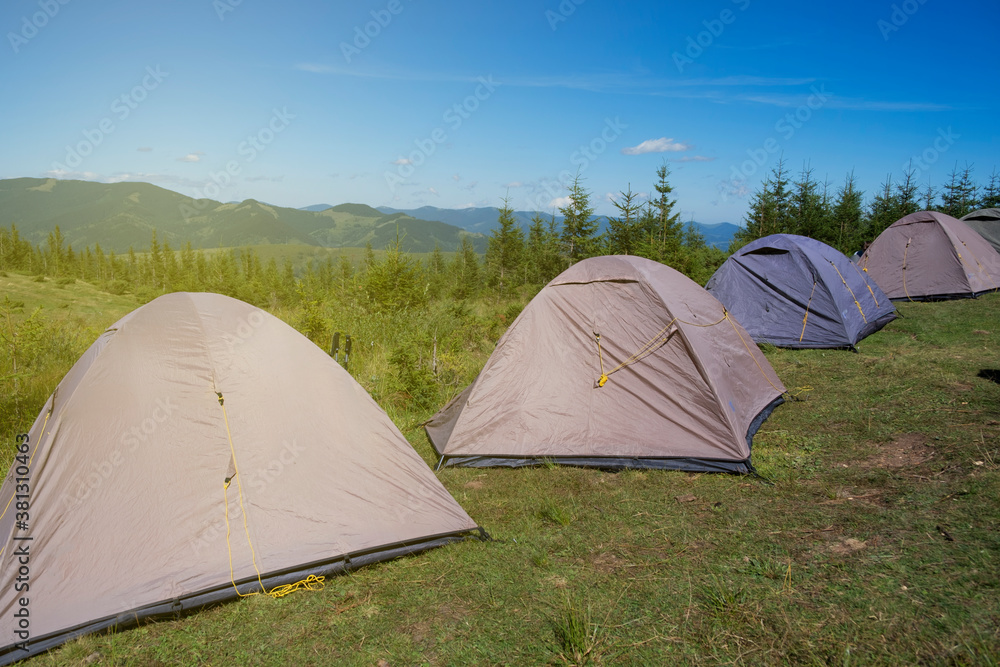 Camping with tents in high mountains on background