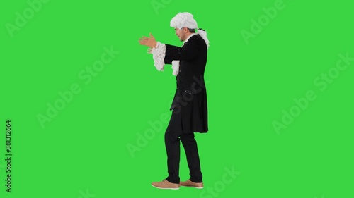 Man dressed like Wolfgang Amadeus Mozart conducting an orchestra on a Green Screen, Chroma Key. photo