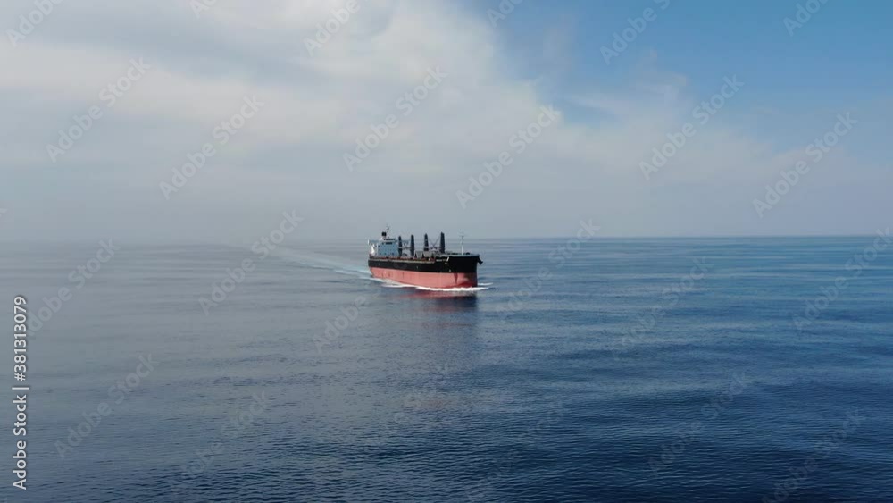 Large cargo ship. A bulk carrier carries cargo across the ocean. Transportation. Delivery. Logistics. A large ship for transporting. Aerial 4k shot.