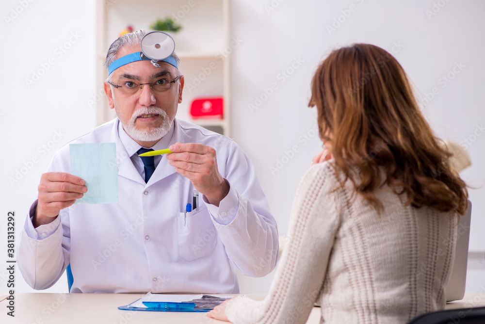 Young woman visiting old male doctor otorhinolaryngologist Young woman visiting old male doctor otorhinolaryngologist