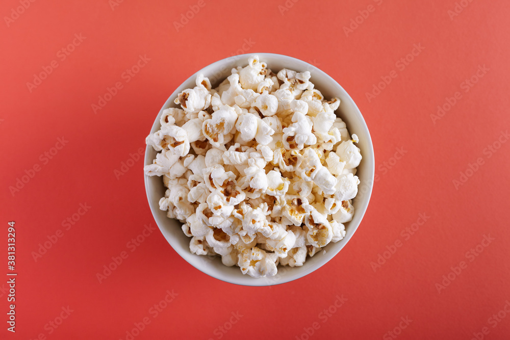 Popcorn in a plate on a orange background top view. Popcorn in a plate on a orange background top view.