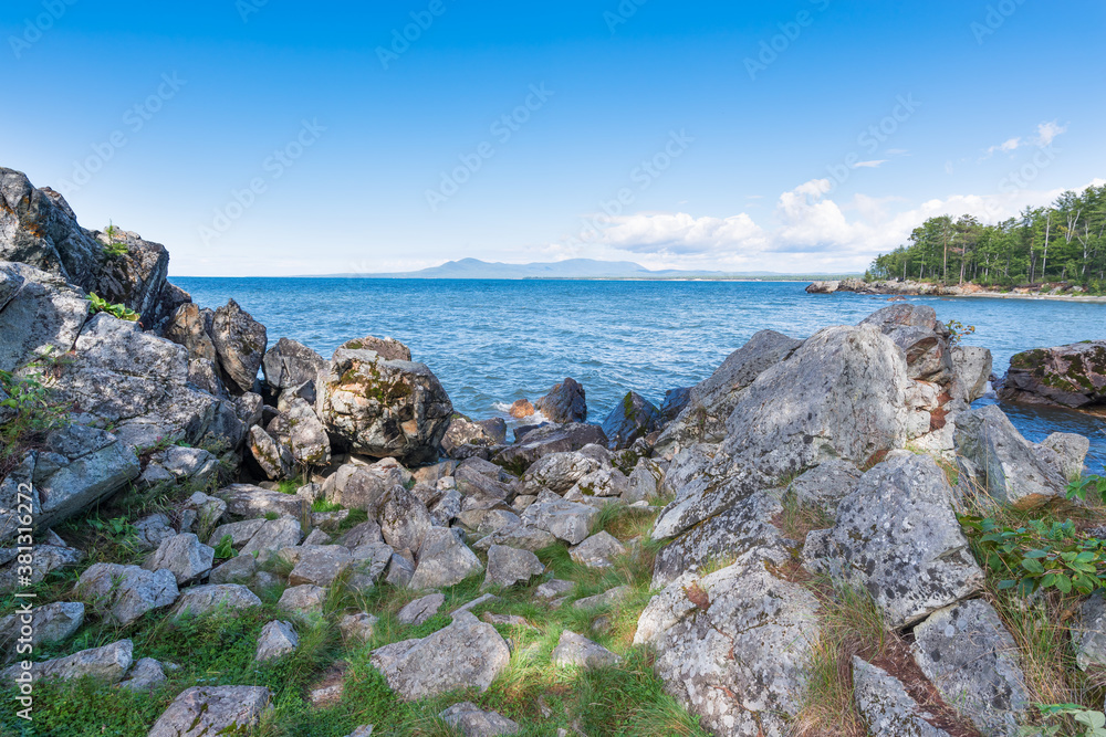 Rocky eastern coast of Lake Baikal in summer. Turquoise colored water under a blue sky. Republic of Buryatia, Russia