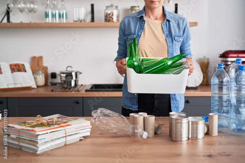 Woman carrying a box full of glass bottles photo