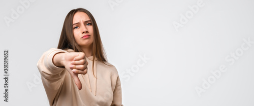 Konstfotografi Young woman looking unhappy and angry showing dislike with thumb down, rejection concept