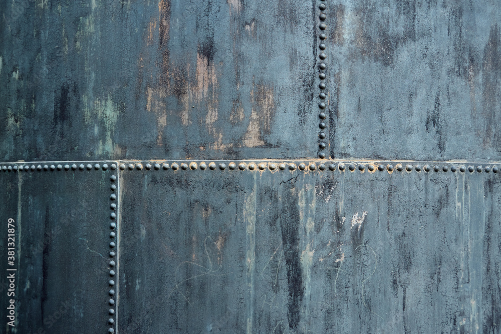 Part of an old storage container made of riveted iron plates, used and dirty, pattern, texture, background