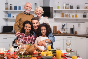 Selective focus of multicultural family hugging while celebrating thanksgiving at home