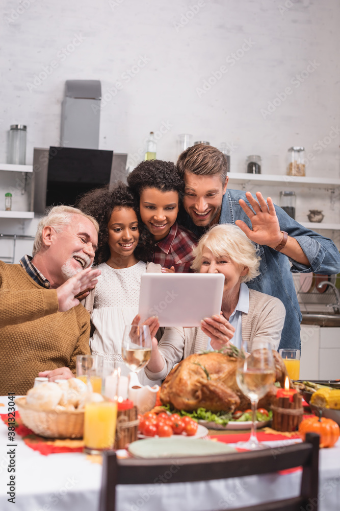 Selective focus of multiethnic family having video call on digital tablet during thanksgiving celebration Selective focus of multiethnic family having video call on digital tablet during thanksgiving celebration