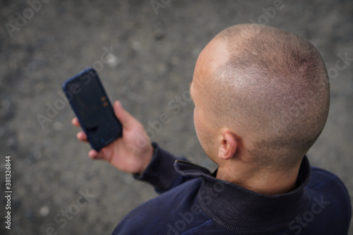 A view of a young man looking into his smartphone.