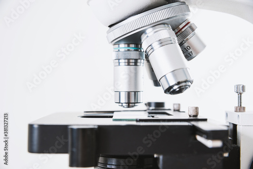 Using a biological microscope. Close-up of the microscope lens. Scientific research concept, using a microscope. Medical examinations, searching for bacteria, diseases, blood tests.