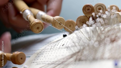 Video detail of bobbin lace handcrafting. Woman hands braiding threads to make a pattern.