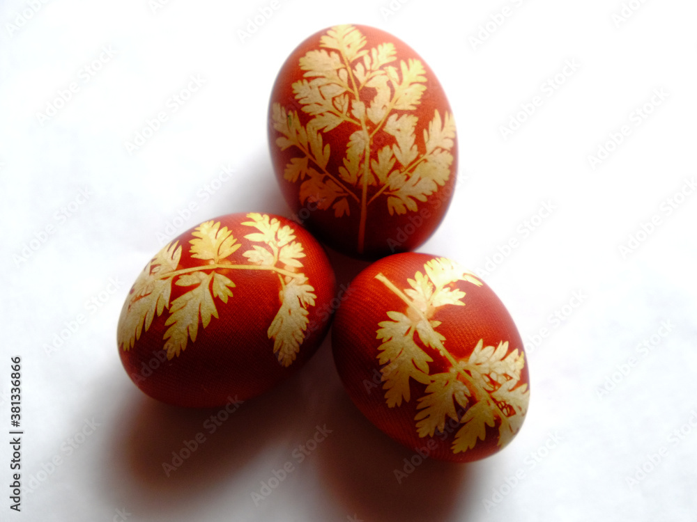 Painted Easter eggs on a white background. Floral pattern on a red eggshell. Festive food. Painted Easter eggs on a white background. Floral pattern on a red eggshell. Festive food.