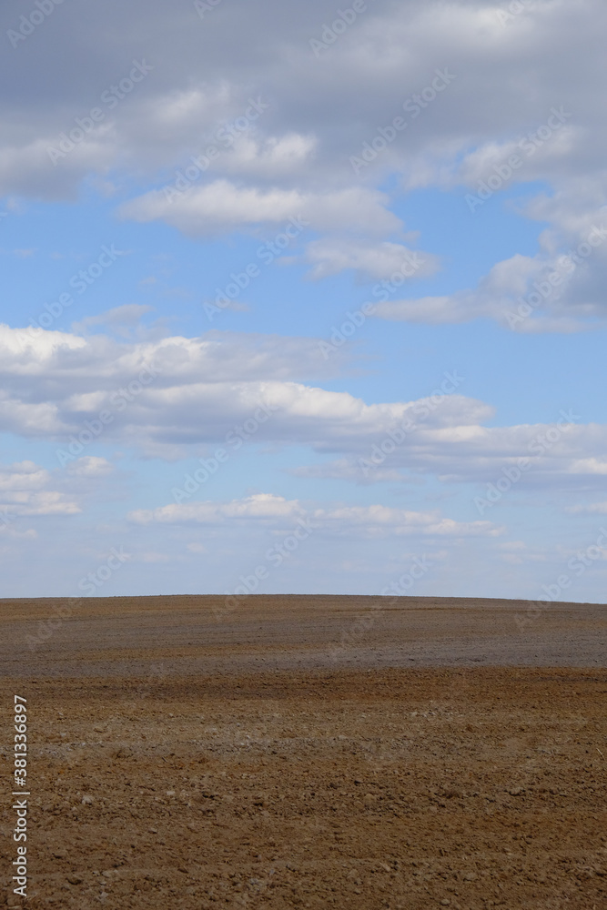 A plowed agricultural field. Blue sky over a farm field.