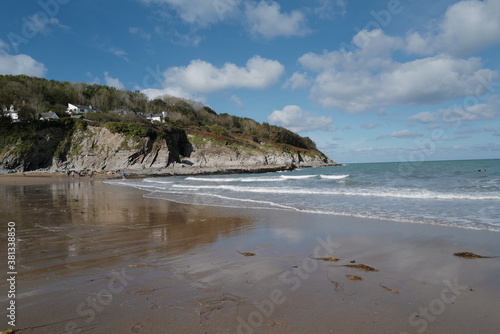 Aberporth beach on a sunny autumn day - clouds reflecting on the water on the sandy beach