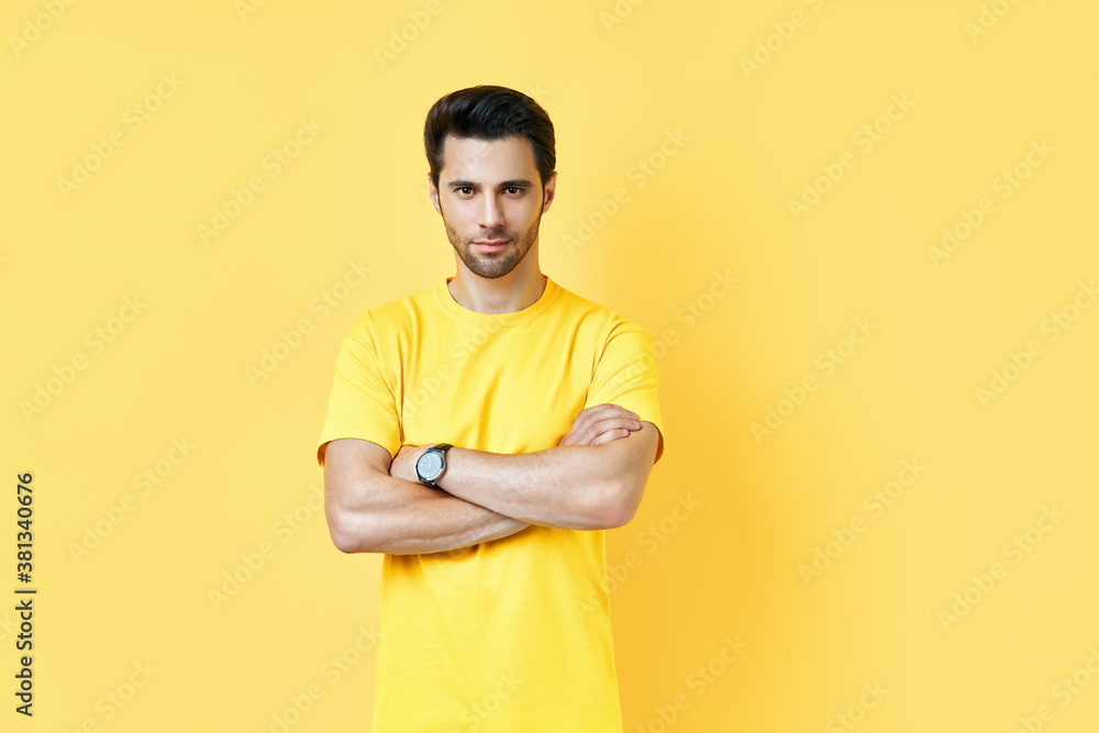 Happy smiling handsome man with crossed arms looking to camera over yellow background Happy smiling handsome man with crossed arms looking to camera over yellow background