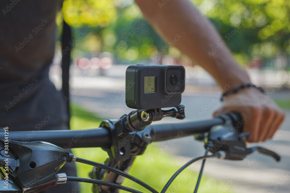 Action camera mounted on the handlebar of a bicycle that a male cyclist is holding Action camera mounted on the handlebar of a bicycle that a male cyclist is holding