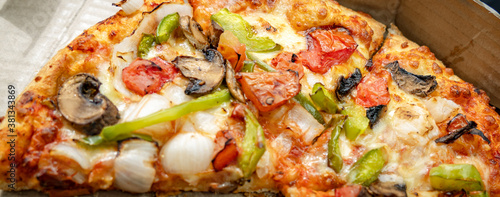 Close up of a hand-tossed Mushroom pizza topped with mushrooms, onions, crispy green bell peppers or capsicum, jalapeños, and fresh tomatoes