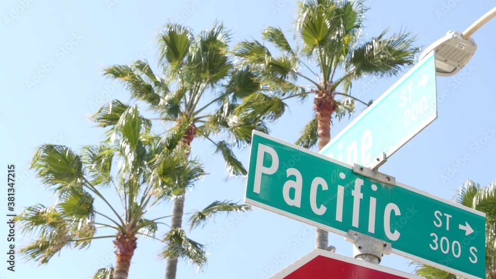 Fototapeta premium Pacific street road sign on crossroad, route 101 tourist destination, California, USA. Lettering on intersection signpost, symbol of summertime travel and vacations.Signboard in city near Los Angeles