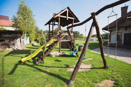 Wallpaper Mural Playground in the backyard with slide and swing - a place for children to play and relax Torontodigital.ca