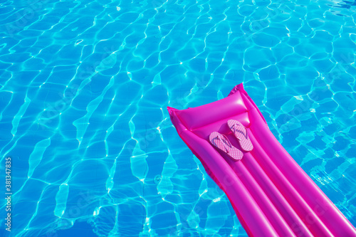 Beach summer holiday background. Inflatable air mattress, flip flops on swimming pool. © nata777_7