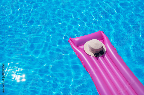 Beach summer holiday background. Inflatable air mattress, flip flops and hat on swimming pool. © nata777_7
