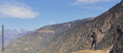 Photography tourist is taking photos of beautiful nature and scenic snow capped peak of hima