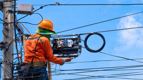 Foto Rear view of technician on wooden ladder is installing fiber optic cable and int