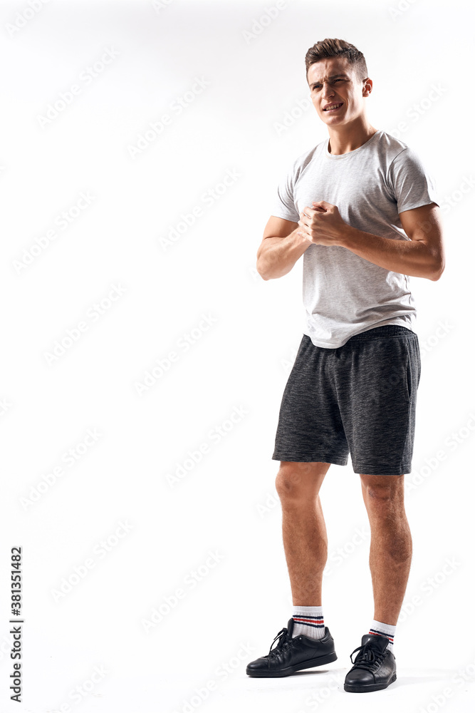 Athletic man on a light background in full growth and jogging charging shorts sneakers t-shirt Athletic man on a light background in full growth and jogging charging shorts sneakers t-shirt