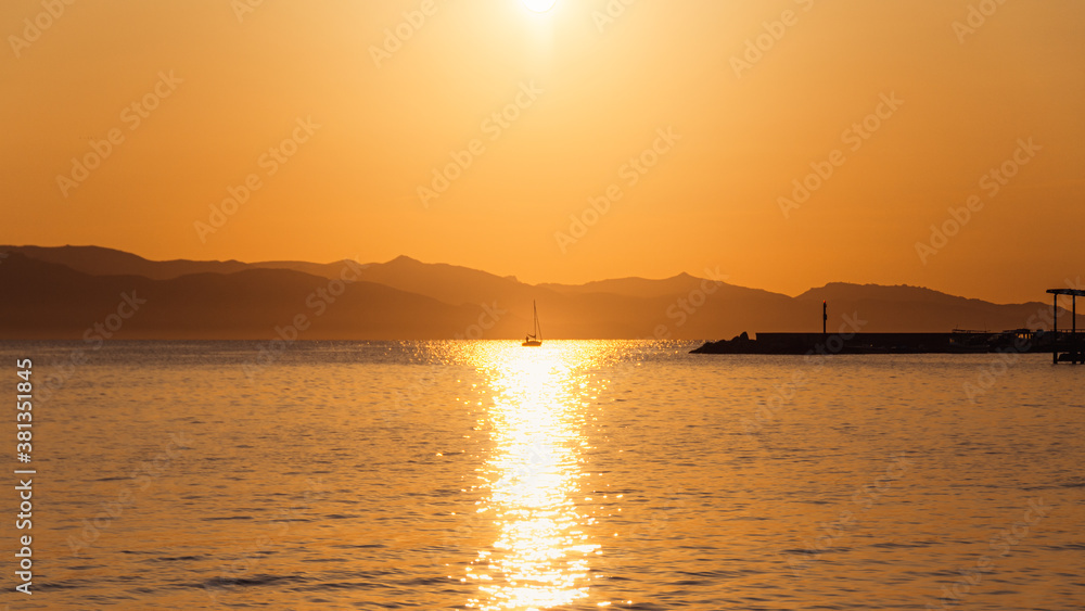 Golden hour view of a small sail boat sailing on the beach of Marina Piccola