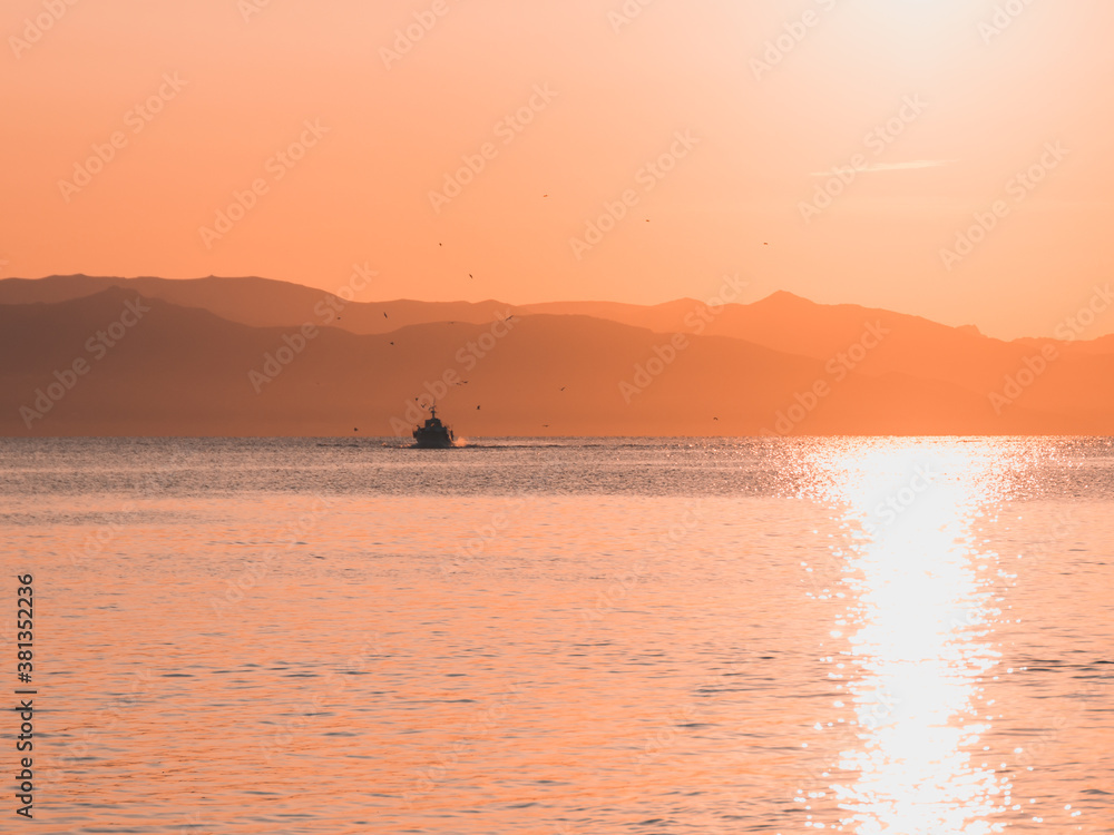 Small yatch sailing on the beach of Marina Piccola at sunrise