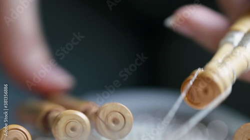 Video detail of bobbin lace handcrafting. Woman hands braiding threads to make a pattern.