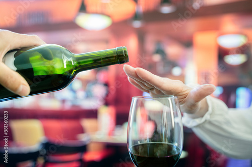Canvas Print Woman hand rejecting more alcohol from wine bottle in bar