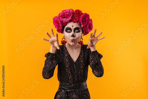 Photo of girl in halloween makeup and flower wreath posing at camera