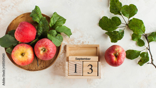 ABanner with a wooden calendar on September 13 and apples. Autumn holiday, the holiday of autumn pies and Charlotte. photo