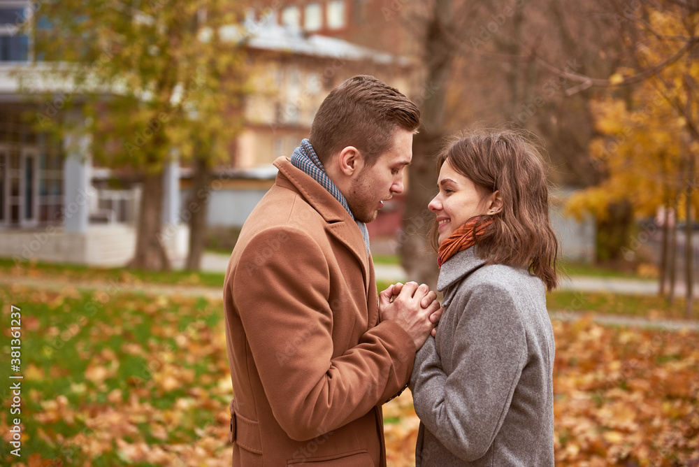 Fototapeta premium Young beautiful couple walking and hugging in the autumn park 