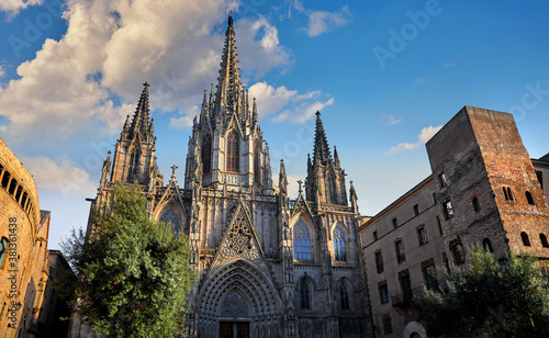 Gothic cathedral in Barcelona, Catalonia, Spain. Entrance in Barcelona Cathedral with tower. Ancient architecture of old town with medieval houses. Blue evening sky with clouds and antique street.