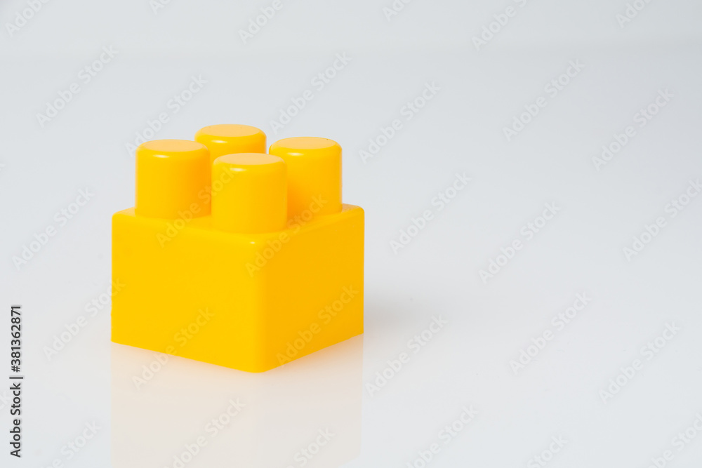 Fototapeta premium Yellow cube block constructor on a white background with copy space. Construction idea concept