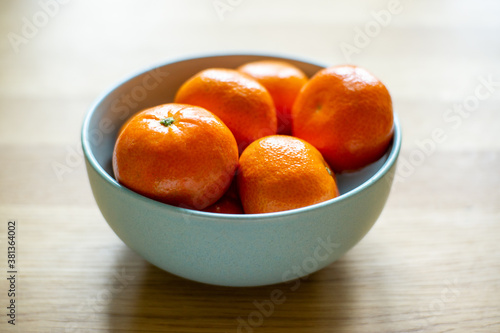 Juicy tangerines in a turqoise bowl. Healthy food, tropical fruits and eating vitamins concept.
