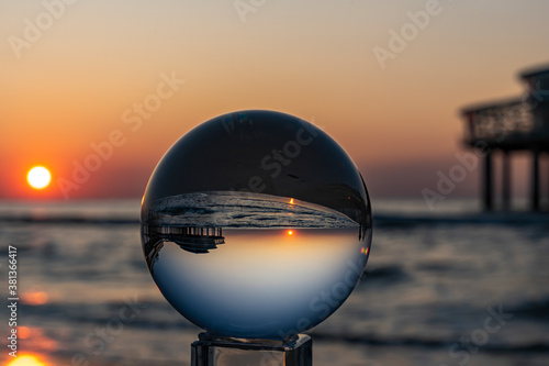 Fotografia The setting sun at the Pier in Scheveningen is inverted in the Lens Ball