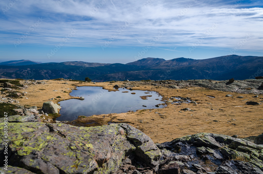 Fototapeta premium Small lake on a rocky mountain landscape on Guadarrama mountain range, Peñalara, Madrid, Spain