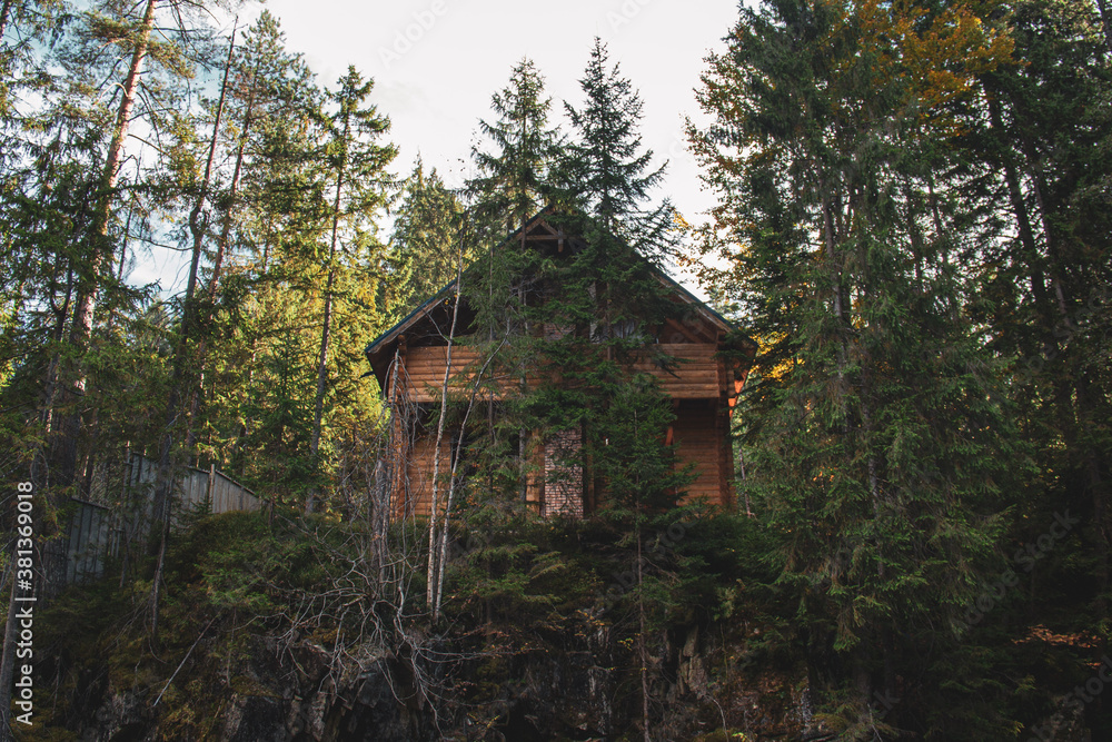 Lonely wooden house on the small cliff in the forest