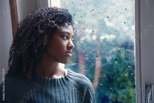 Canvas Print Young worried woman looking out of the window