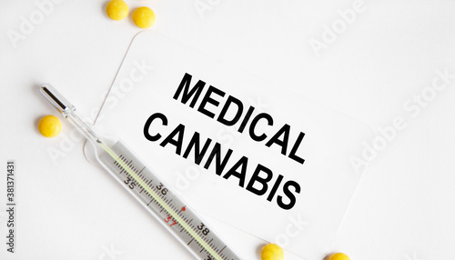 Medical CANNABIS is the inscription on the card. Nearby are yellow pills and a thermometer.