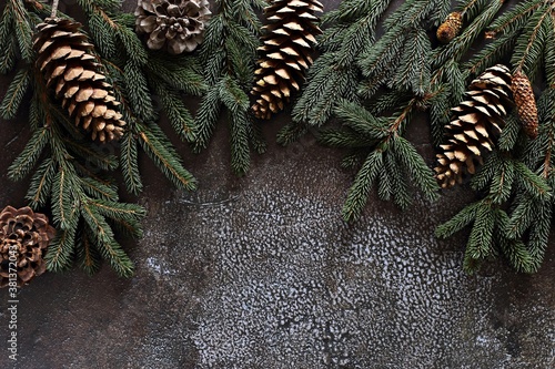 Christmas dark background with fir branches and cones. Overhead view, copy space