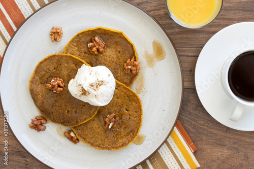 Pumpkin Pecan Pancakes with Syrup and Whipped Cream