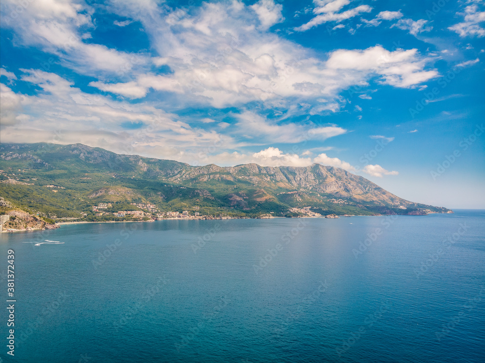 Beautiful view from sea to Budva coast on background of mountains, Montenegro. Drone aerial photo