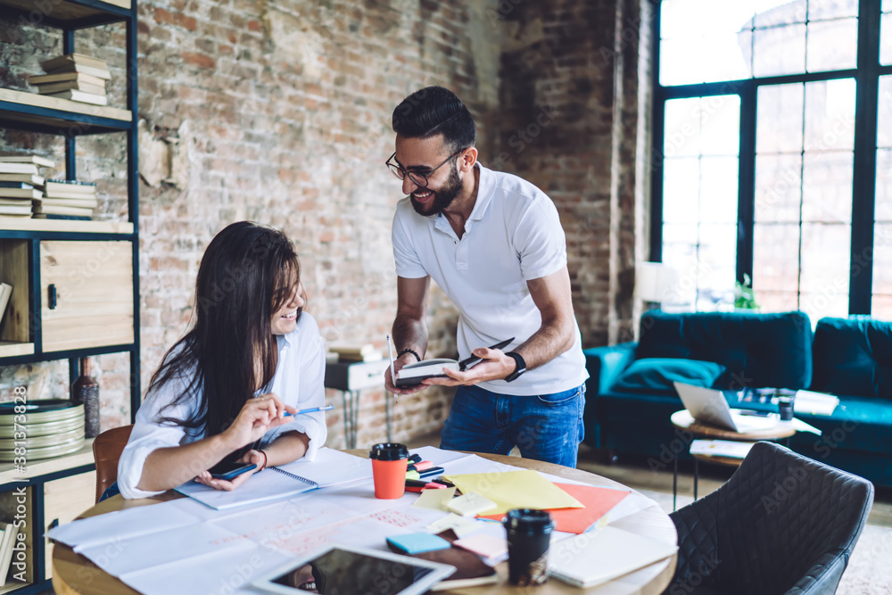 Cheerful coworkers developing project together Cheerful coworkers developing project together